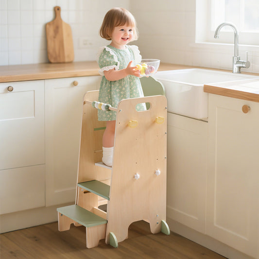 ROBUD Toddler Standing Tower with young girl in floral dress standing on top step beside kitchen sink in bright home setting