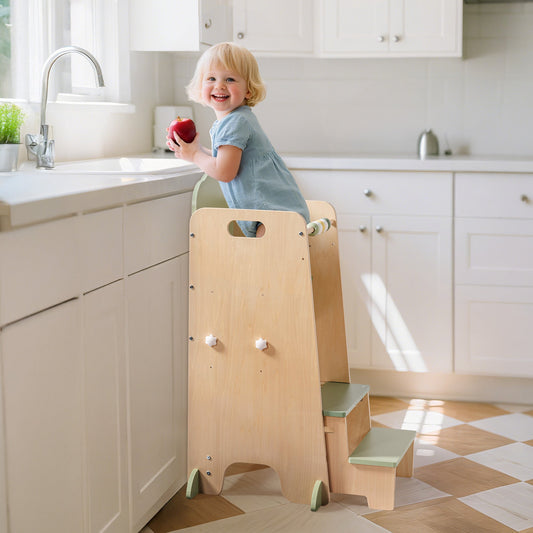 Green two-step kitchen helper tower, toddler reaching the counter in a white and natural wood kitchen