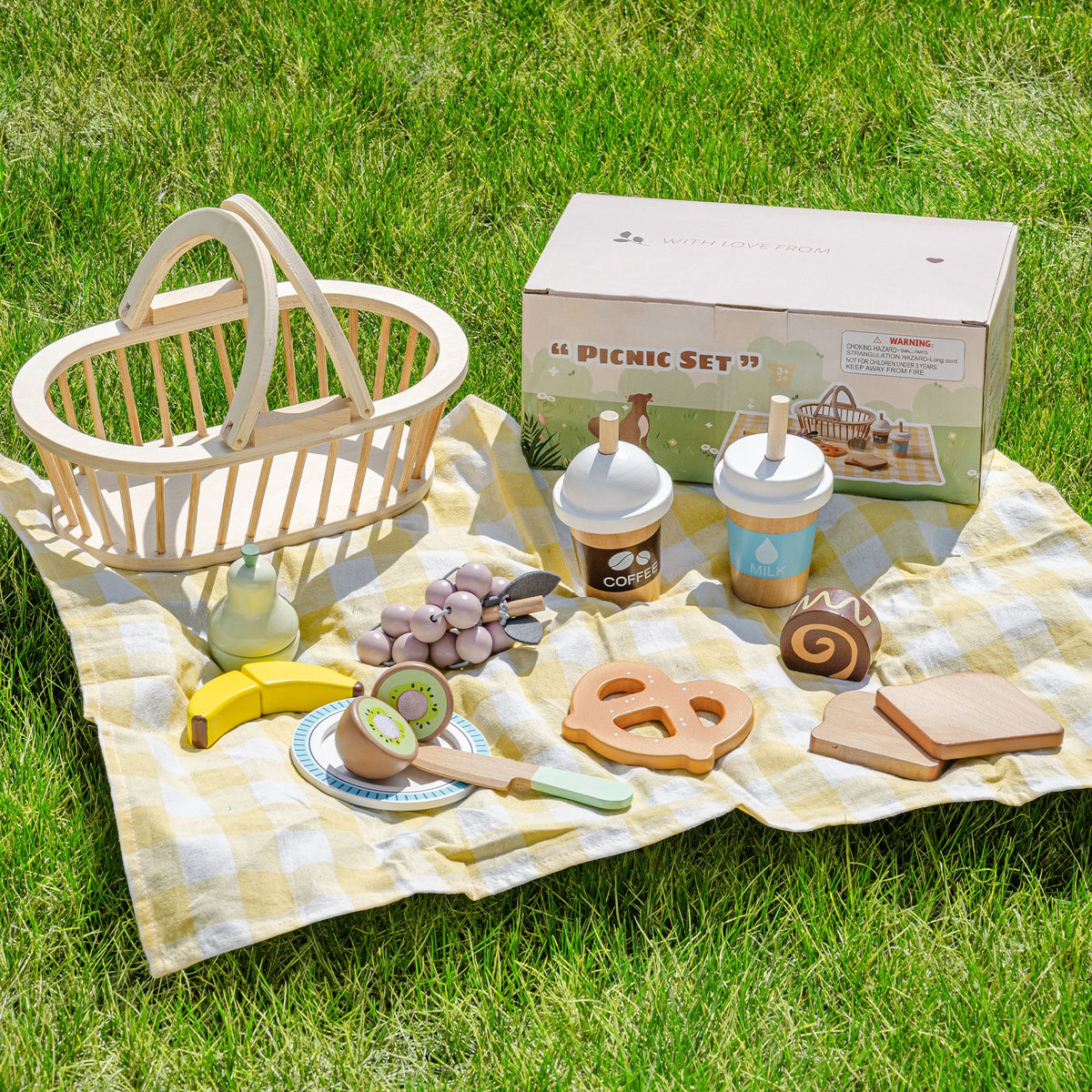 Wooden picnic play food set arranged with basket, plates, and food pieces on a picnic blanket