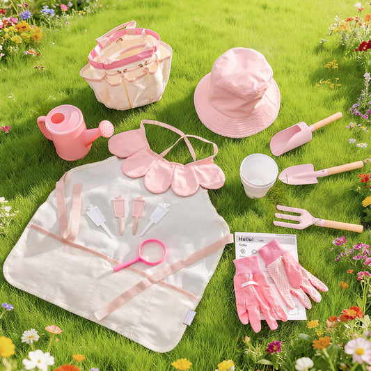 Light pink children's gardening set flat-lay on grass: tote bag, hat, apron, gloves, watering can, tools