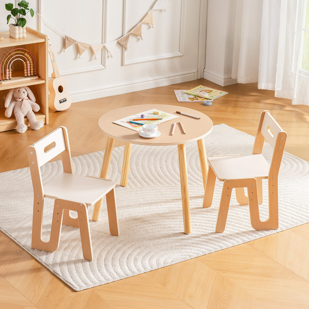 Natural beech and white round kids table and two chairs, front view in a bright playroom
