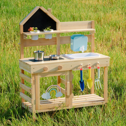 Outdoor wooden mud kitchen with sink, chalkboard, and shelving, front view in a garden setting
