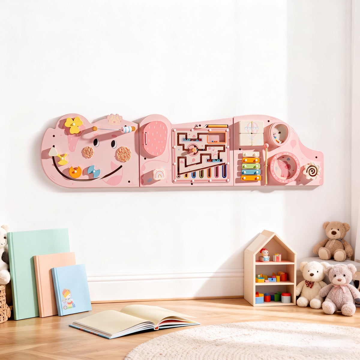 Pink elephant activity busy board mounted on the wall in a styled room with children's books and a teddy bear nearby
