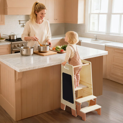 Brown kitchen helper tower with chalkboard panel, child standing on the top step in a white kitchen
