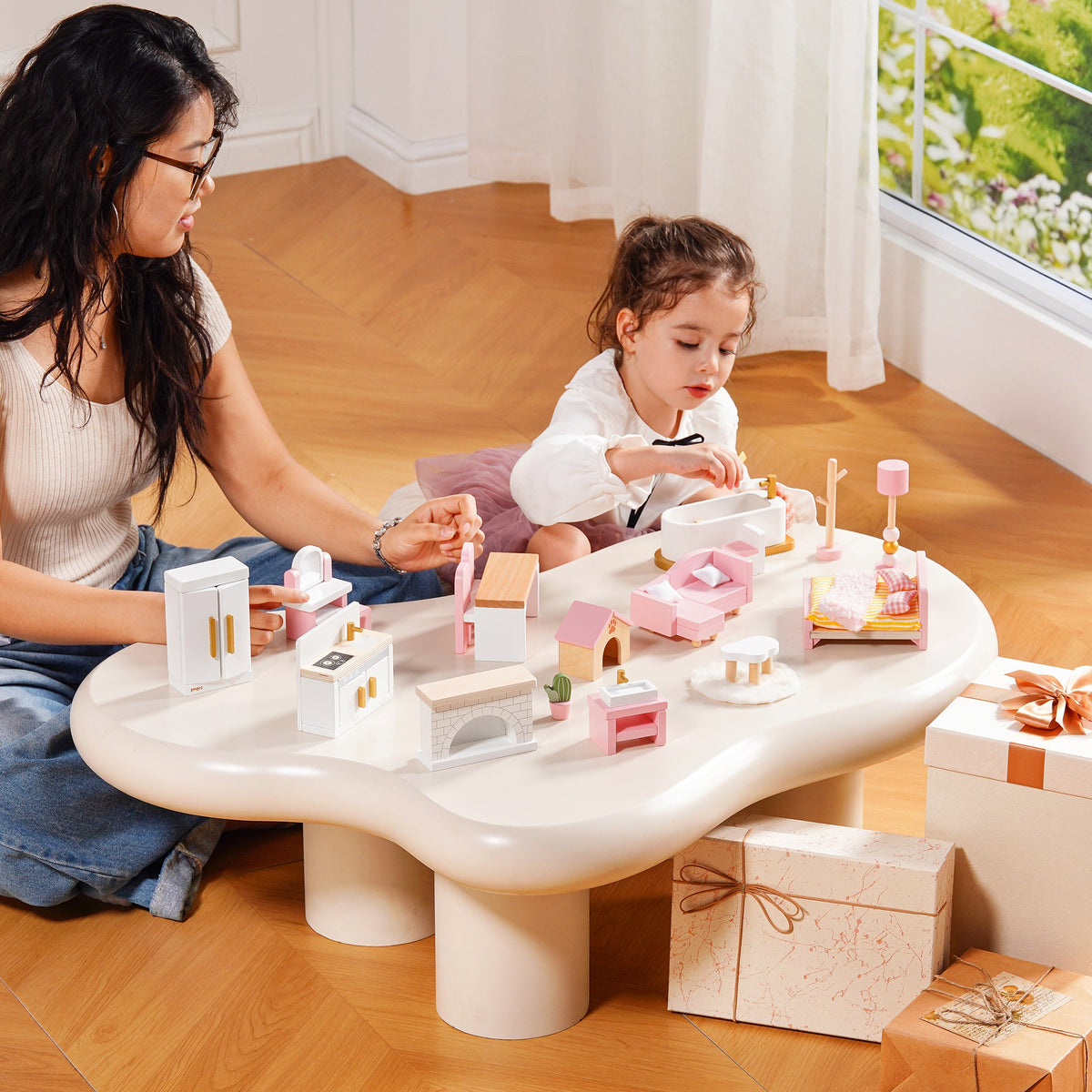 Mother and child playing with ROBUD Wooden Dollhouse Furniture Pink at a white cloud-shaped table in a bright airy living room