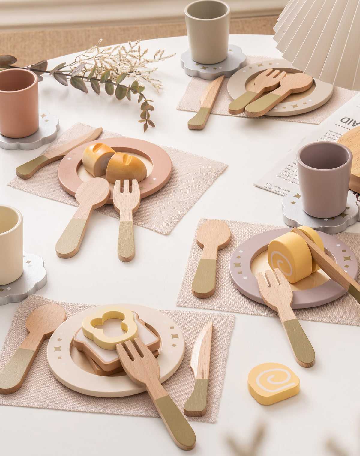 ROBUD wooden play dishes four-set arranged on linen tablecloth with wooden food pieces in airy white setting