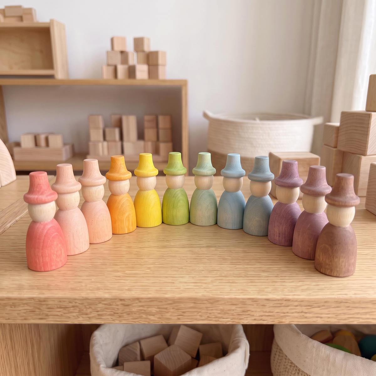 12 pastel-colored wizard peg dolls in a row on a wood table (Pastel 12)