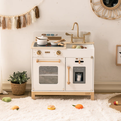 White ROBUD Montessori wooden play kitchen with gold faucet and fittings, shown in a bright home playroom with a woven basket and framed art
