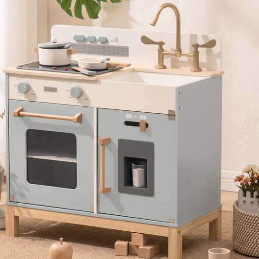Blue-grey wooden play kitchen with white counter and brass bridge faucet in a bright playroom