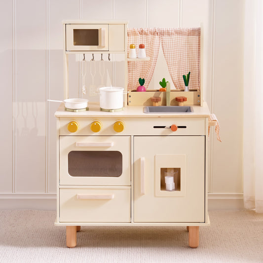 Cream wooden play kitchen with microwave, gingham curtain and gold knobs in a bright playroom