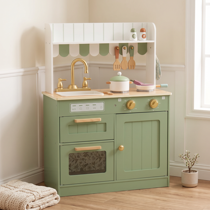 Sage green wooden play kitchen in a cozy playroom corner with a folded blanket nearby, no people