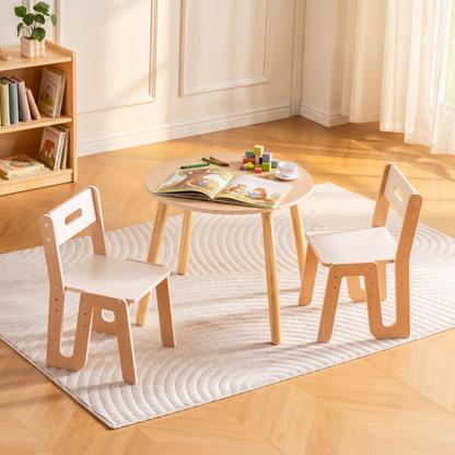 Natural beech and white round kids table and two chairs in a sunlit reading corner with a bookshelf, a picture book open on the table, no people